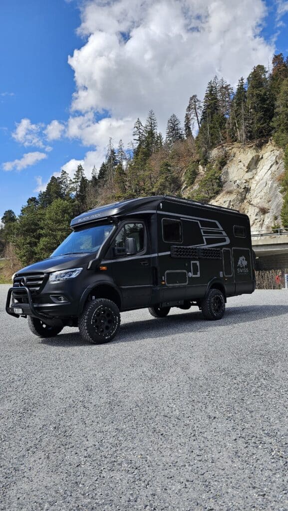 Schwarzes Swiss Venture Expeditionsmobil auf Mercedes Sprinter Basis in den Bergen