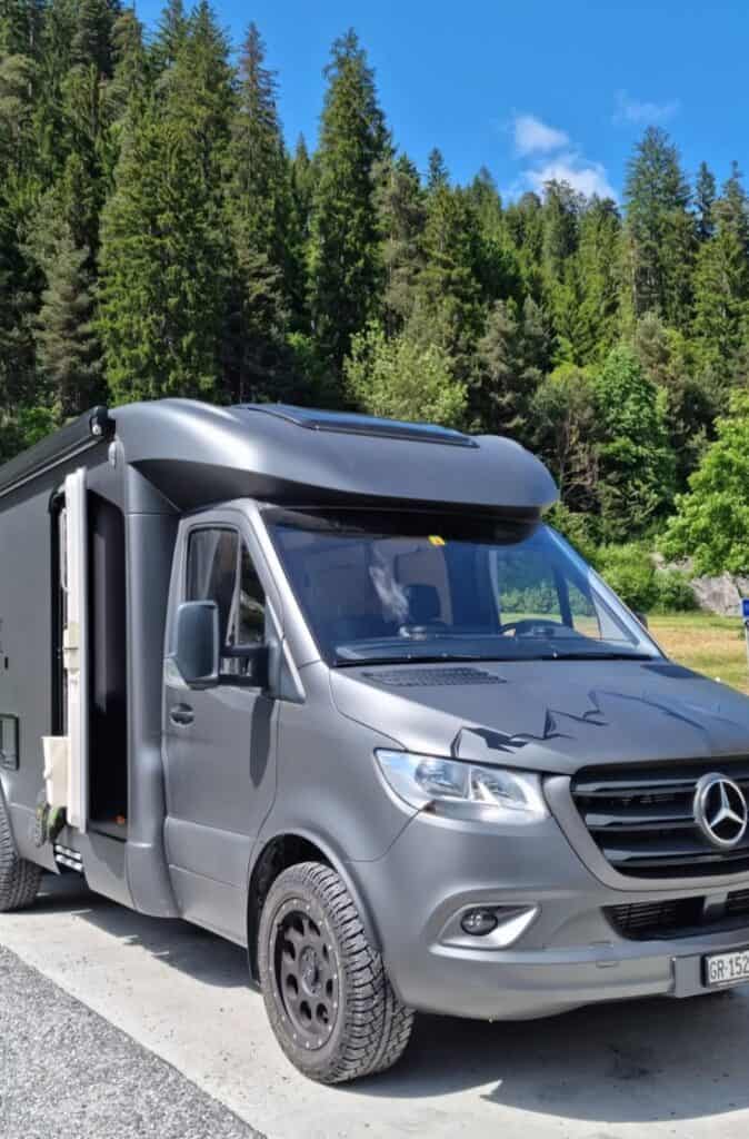 Grauer Mercedes Sprinter 4x4 Offroad-Camper im Wald